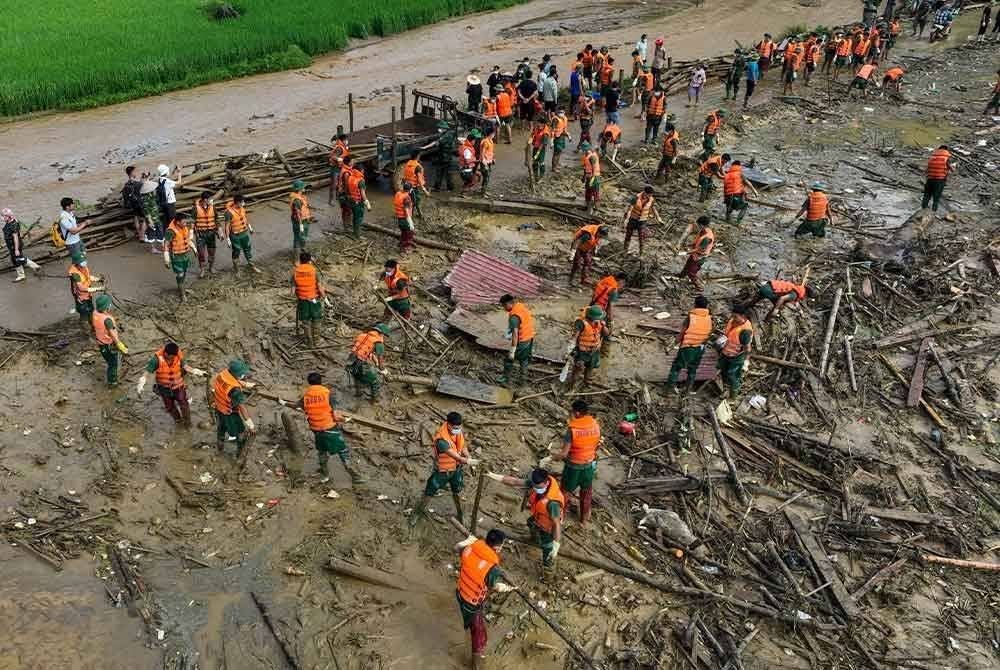 Pasukan penyelamat membersihkan rimbunan kayu di Lang Nu, Vietnam.