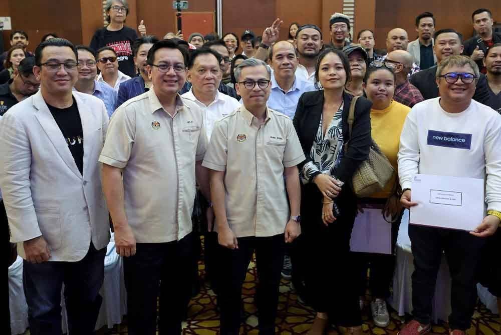 Fahmi (tengah) pada majlis sembang santai bersama penggiat industri kreatif Sabah dan Sarawak di Intan Jalan Sulaman-Tuaran pada Sabtu. Foto Bernama