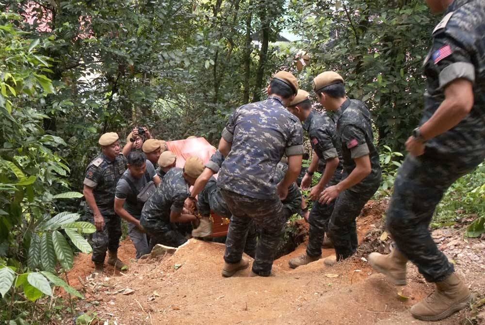 Anggota pasukan VAT69 Komando mendaki lereng bukit setinggi 150 meter sambil mengusung keranda mendiang untuk disemadikan di Tanah Perkuburan Orang Asli Batu Berangkai, Kampar.