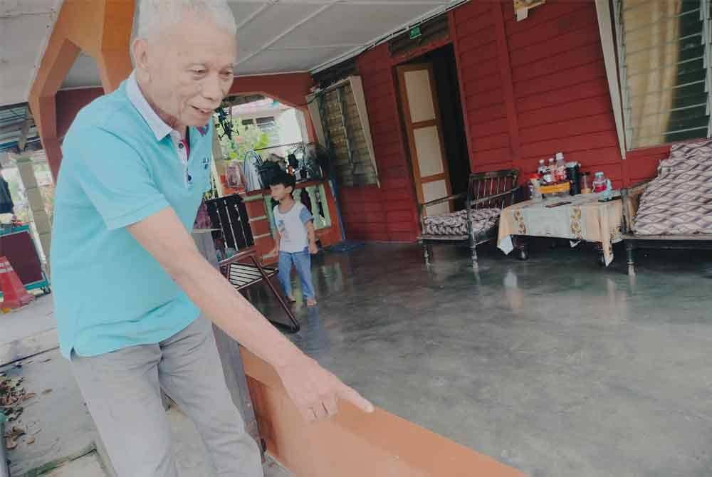 Saim menunjukkan tembok di depan pintu rumah untuk mengelak air banjir memasuki rumah.