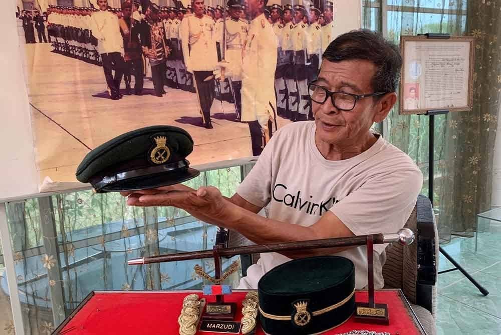 Wan Marzudi menunjukan koleksi topi dan tongkat yang masih disimpan olehnya walaupun ia telah berusia lebih 30 tahun. Foto Bernama