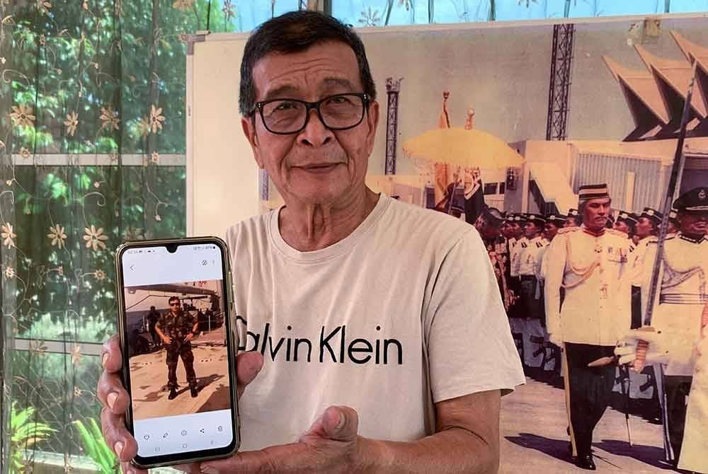 Wan Marzudi menunjukkan gambar lama ketika beliau masih bergelar berkhidmat di Rejimen Askar Melayu Diraja (RAMD) pada sesi temu ramah di kediamannya baru-baru ini. Foto Bernama