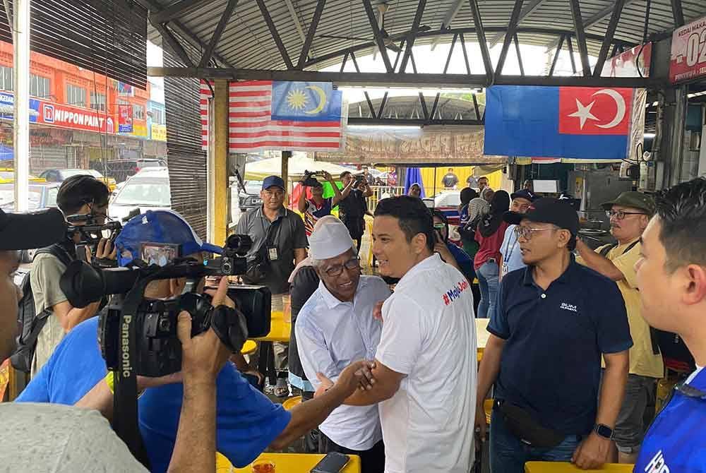 Syed Hussien menyantuni masyarakat di Gerai MPK, Taman Makmur sempena hari kedua kempen PRK Mahkota pada Ahad.