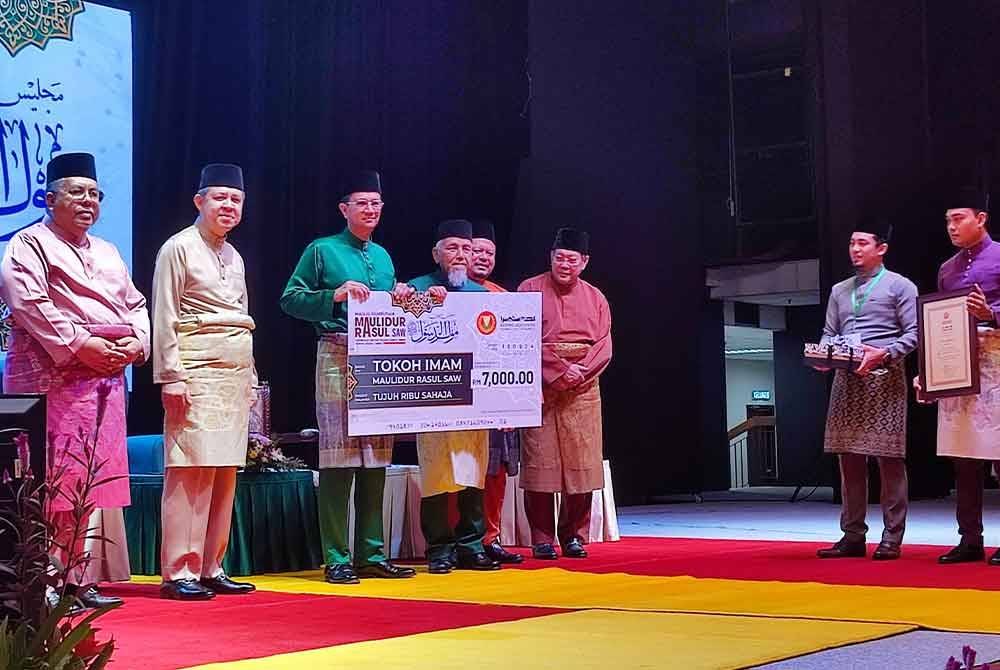 Tengku Sarafudin (tiga, kiri) mewakili Sultan Kedah berkenan menyampaikan Anugerah Tokoh Imam Maulidur Rasul kepada Imam Masjid An-Nur Pokok Sena, Ismail Jaafar (tengah) pada Majlis Sambutan Maulidur Rasul Peringkat Negeri Kedah Tahun 2024 di Dewan Seri Negeri, Wisma Darul Aman, di Alor Setar, pada Isnin.