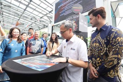 Fahmi menurunkan tandatangannya pada simbolik perasmian Pesta Seni Tradition In Tune 2024 di Pusat Konvensyen Antarabangsa Sabah (SICC), pada Isnin.