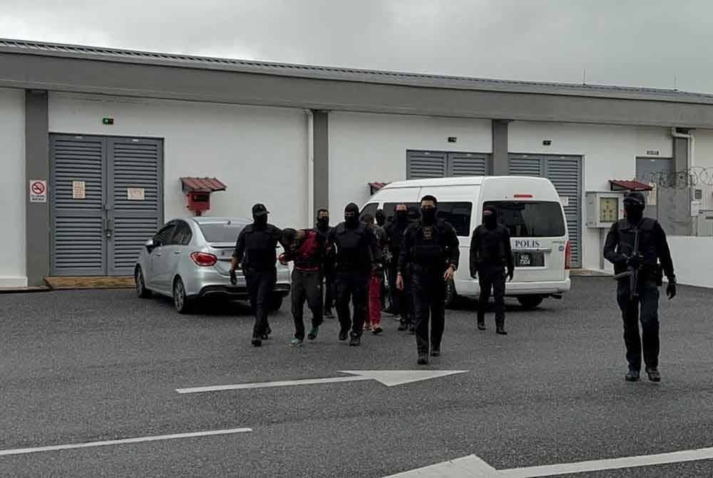 Polis membawa suspek kes tetak bekas pelumba negara ketika permohonan lanjutan reman di Mahkamah Majistret Kangar pada Selasa.