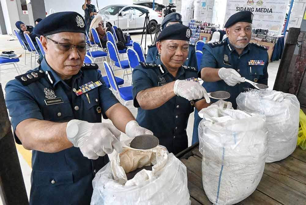 Nadzri (tengah) menunjukkan serbuk biji timah yang berjaya dirampas dan disita.
