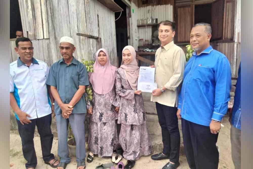 Muhammad Faiz (dua dari kanan) menyampaikan sumbangan kepada Wan Nur’alyaa Syaza.