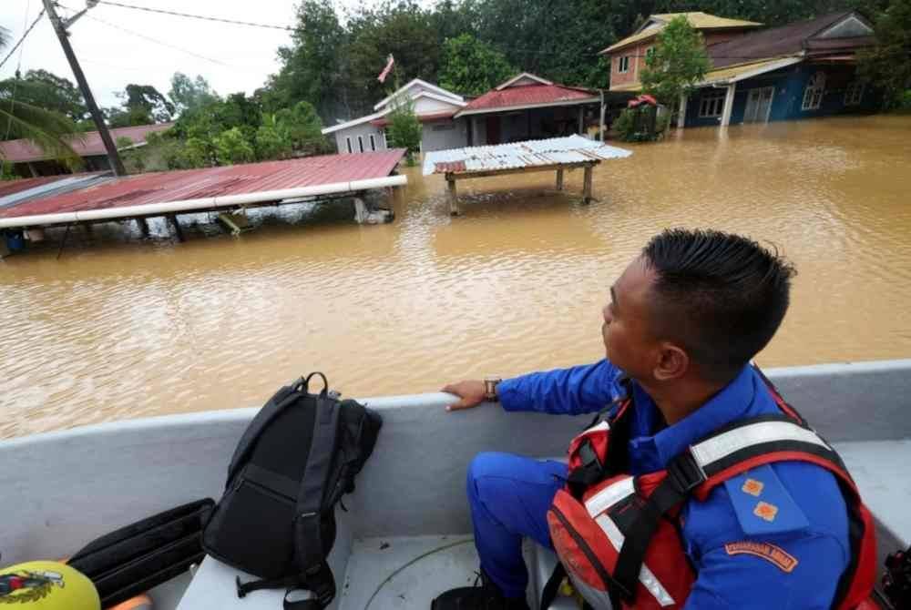 Anggota Angkatan Pertahanan Awam (APM) menjalankan tinjauan ketika banjir di Kampung Padang Luar ketika tinjauan banjir di Kubang Pasu pada Selasa. Foto Bernama