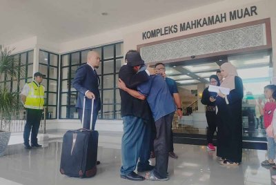 Bapa kepada 'Abang Bas' memeluk erat peguam, Ahmad Zaharil selepas jaminan anaknya selesai dibayar di Kompleks Mahkamah pada Selasa.