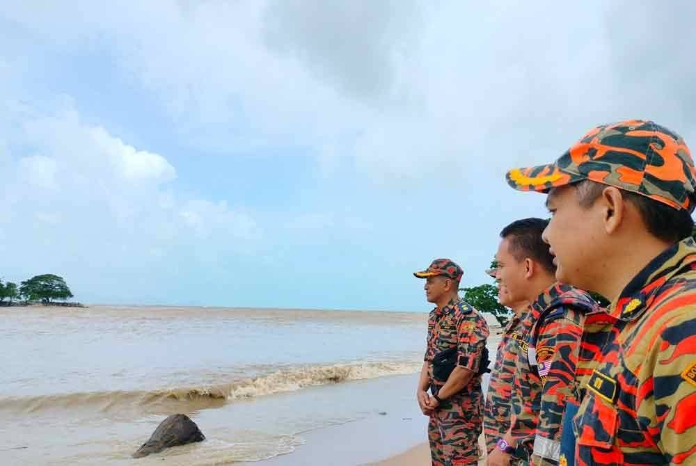 Mohd Naim (kanan) meninjau keadaan air pasang di Pasar Bisik Kota Kuala Muda berdekatan lokasi kejadian.