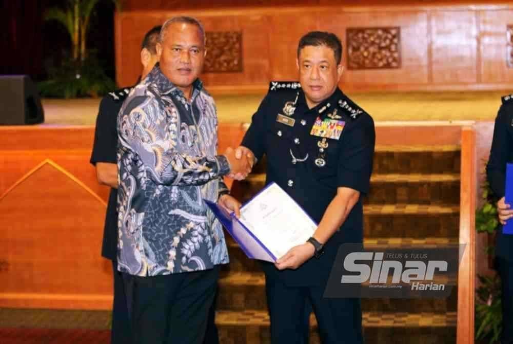 Azizi (kanan) menyampaikan sijil penghargaan kepada bekas Ketua Polis Daerah Ipoh, Yahaya Hassan.