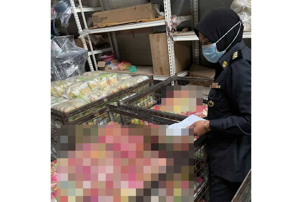 Pegawai penguat kuasa KPDN cawangan Kuala Kangsar memeriksa dengan teliti produk dihasilkan sebuah kilang memproses makanan dalam satu operasi bersepadu melibat beberapa agensi di Sungai Siput pada Rabu.