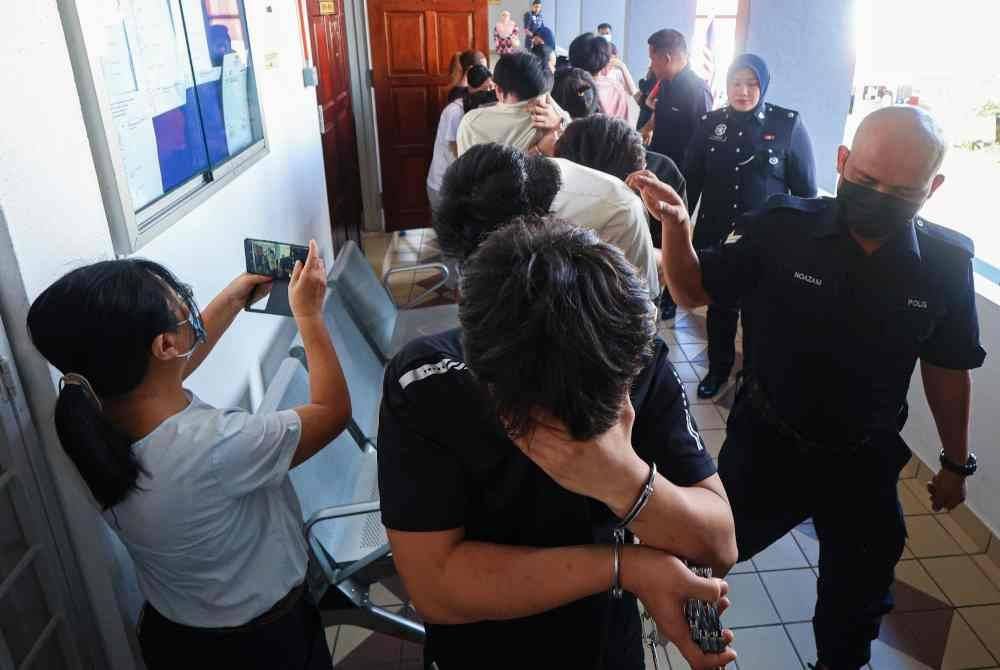 Kesemua tertuduh dibawa keluar dari kamar mahkamah sebaik mengaku tidak bersalah atas pertuduhan menawarkan pekerjaan tidak wujud, bulan lalu.