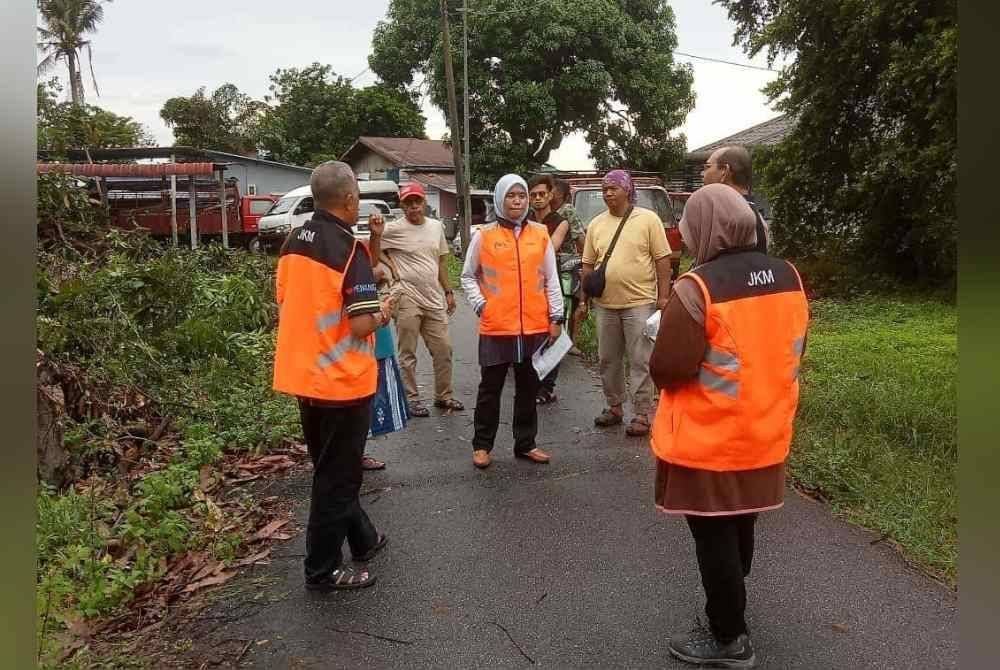 Pegawai JKM ketika memantau keadaan banjir di sekitar Tasek Gelugor pada Khamis.