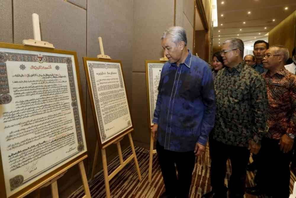 Ahmad Zahid (kiri) melawat reruai pameran selepas merasmikan Konvensyen Sejarah dan Perpaduan Nasional 2024 dengan Tema 'Menelusuri Sejarah: Membina Perpaduan Negara Bangsa', pada Khamis. 