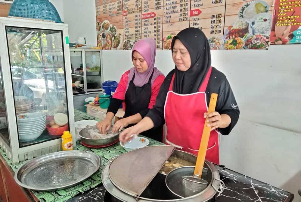 Rohani (kanan) menyediakan hidangan untuk pelanggannya.