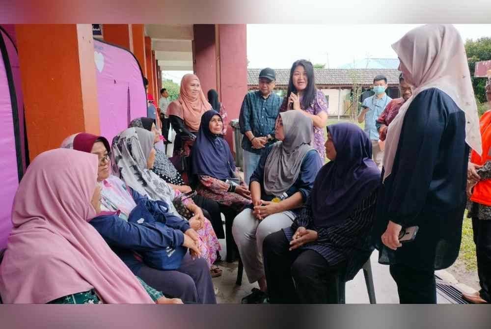 Siew Khim (kanan) ketika menziarahi mangsa banjir di PPS Lahar Yooi pada Khamis.