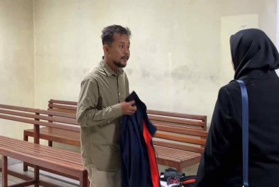 Tertuduh (kiri) ketika hadir di Mahkamah Butterworrh pada Khamis.