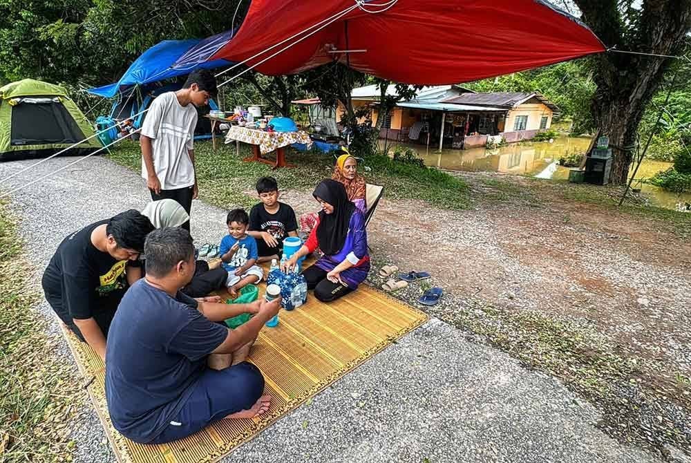 Keluarga Aminah mengambil inisiatif mendirikan khemah di atas ban sungai di hadapan rumah mereka di Kampung Padang Teja, Jitra di Kubang Pasu.