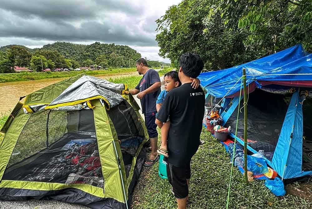 Anak-anak dan menantu Aminah memasang khemah sebagai tempat berteduh.