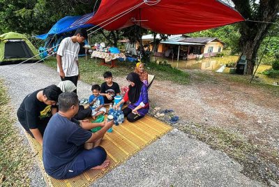 Keluarga Aminah mengambil inisiatif mendirikan khemah di atas ban sungai di hadapan rumah mereka di Kampung Padang Teja, Jitra di Kubang Pasu.