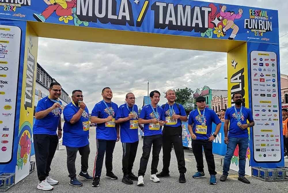 Ahimmat (empat, kiri) dan Adam (sebelah) bergambar kenangan selepas pelepasan peserta.