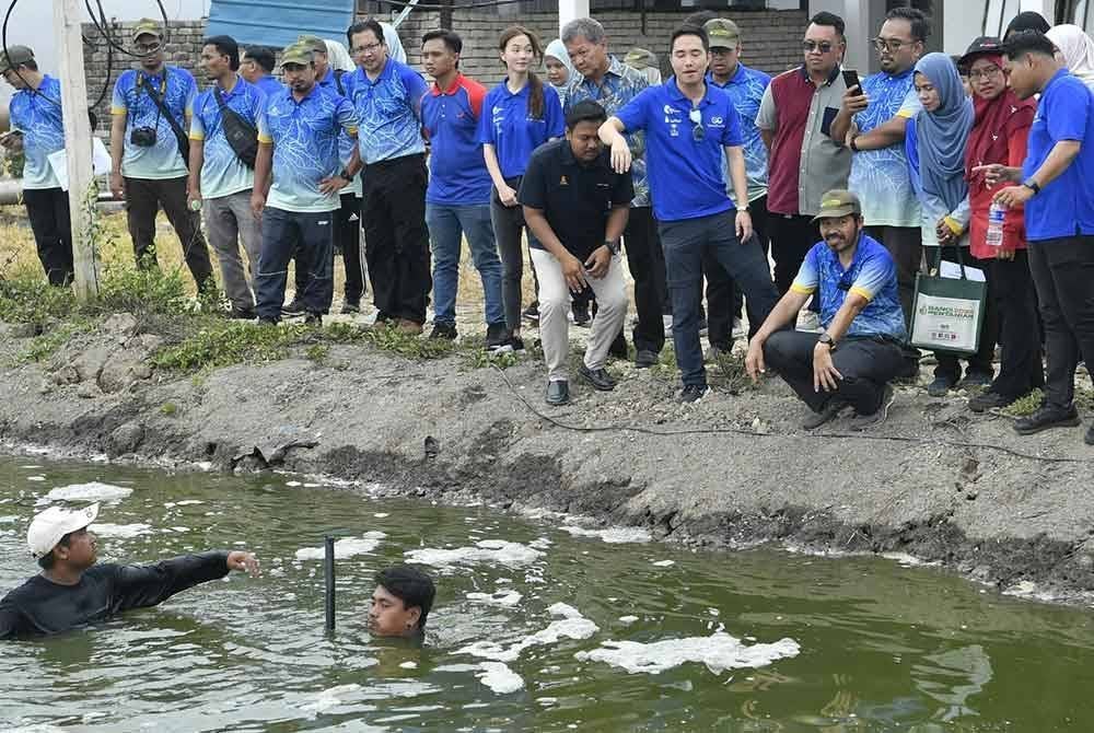 Mohd Uzir melihat proses membawa naik udang harimau di Pertubuhan Global Goodway (M) Sdn Bhd, di Sungai Nipah Farm pada Sabtu.