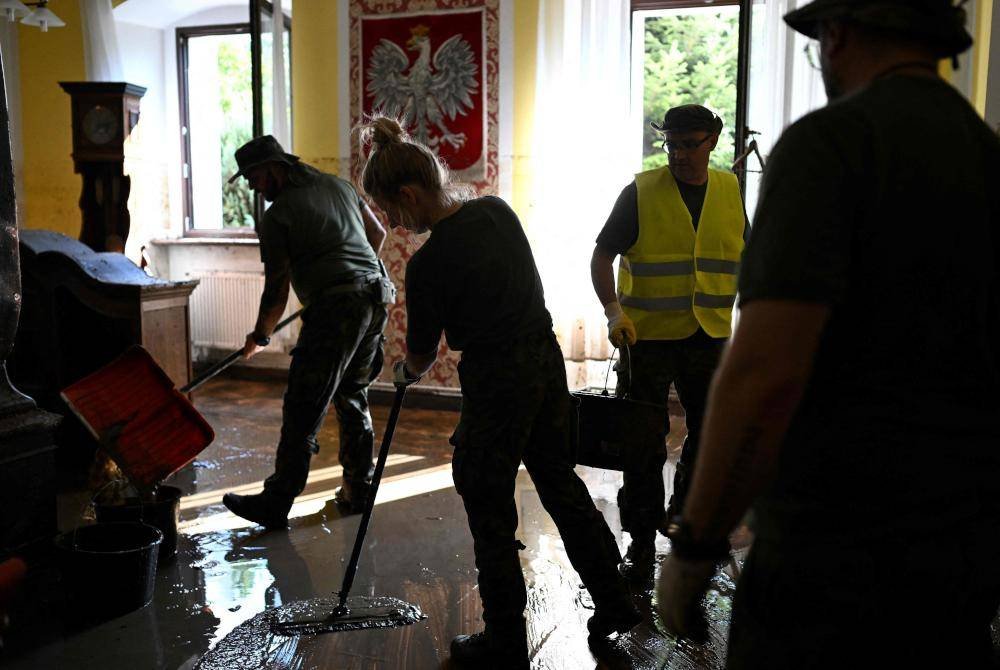 Anggota tentera Poland membersihkan bangunan pejabat berikutan banjir di Ladek-Zdroj, selatan Poland. Foto AFP