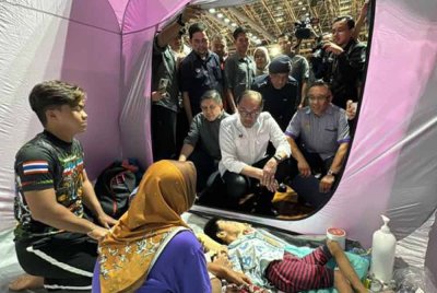 Anwar menyantuni mangsa banjir dan menyampaikan sumbangan kepada kanak-kanak OKU, Mohd Afiq Ramadhan Abdullah di pusat pemindahan sementara di Alor Setar, Kedah, pada Sabtu. Foto Awani