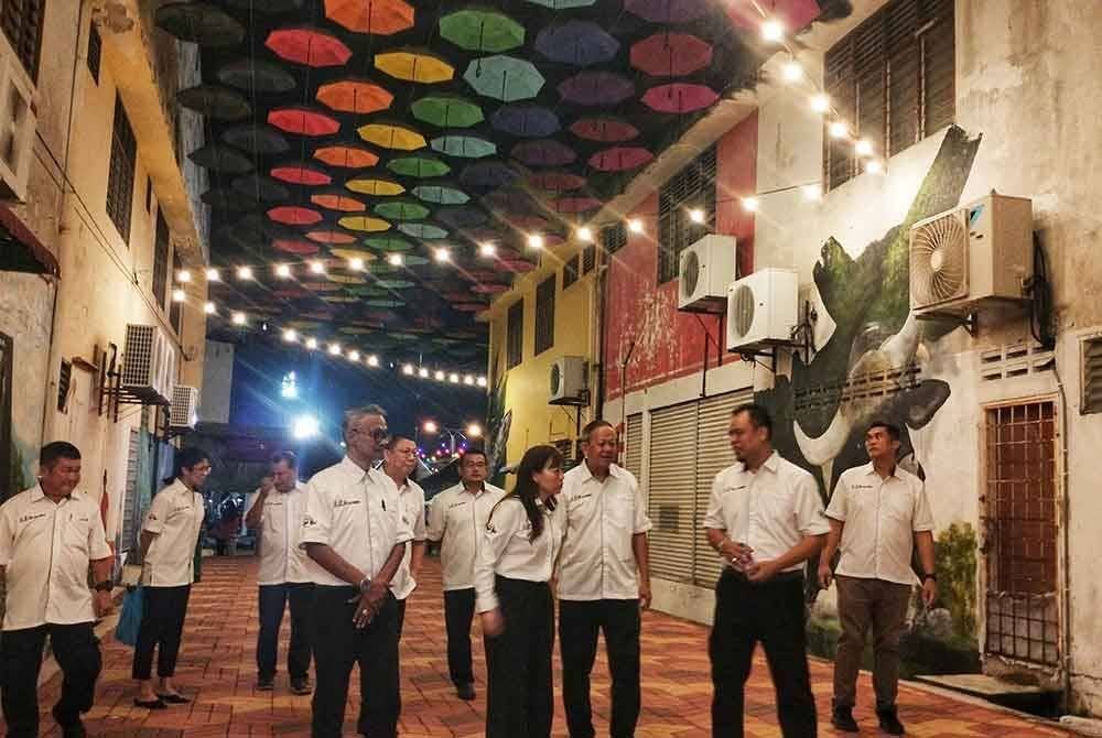Yu Man (dua dari kiri) meluangkan masa meninjau Temerloh Umbrella dan Art Street bersama Suris (kiri) yang turut dirasmikan pada Sabtu.