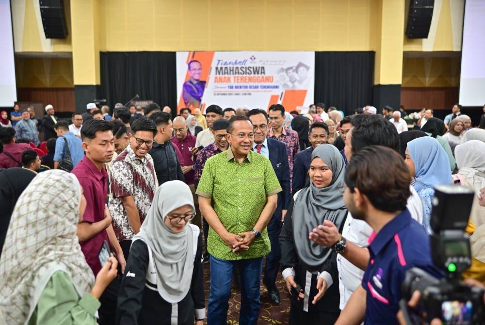 Ahmad Samsuri (tengah) beramah mesra bersama mahasiswa selepas mengadakan pertemuan bersama mahasiswa anak Terengganu di Pulau Duyong, Kuala Nerus, pada Ahad.
