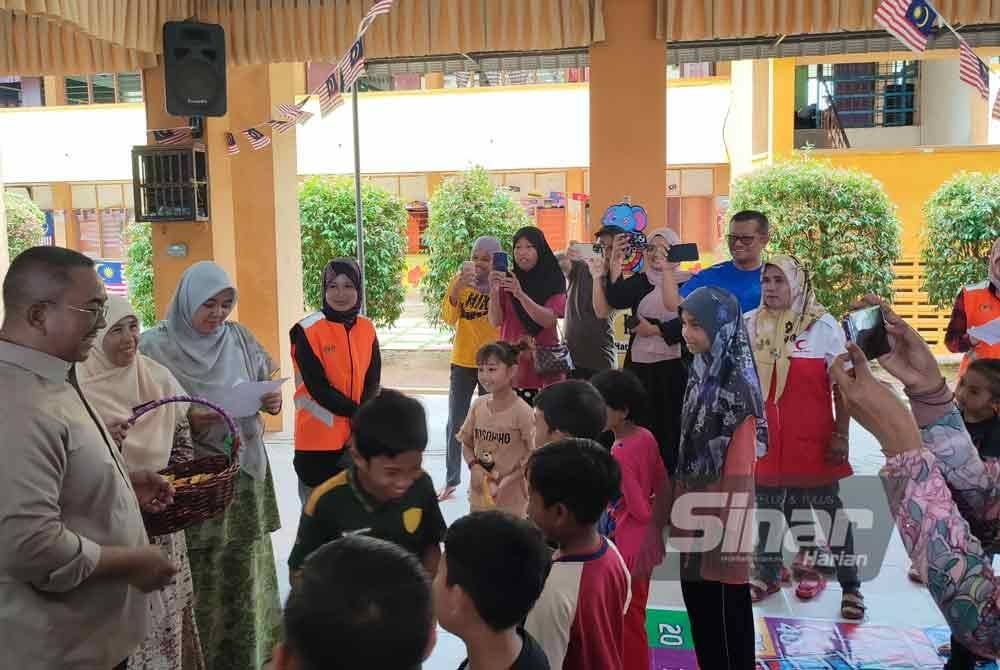 Muhammad Sanusi (kiri) beramah mesra dengan kanak-kanak di PPS SMK Tanah Merah pada Ahad.