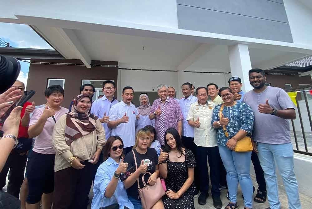 Ahmad Zahid bergambar bersama pembeli rumah selepas Majlis Merealisasikan Rumah Mampu Milik Kluang di Taman Kluang Perdana, pada Ahad.