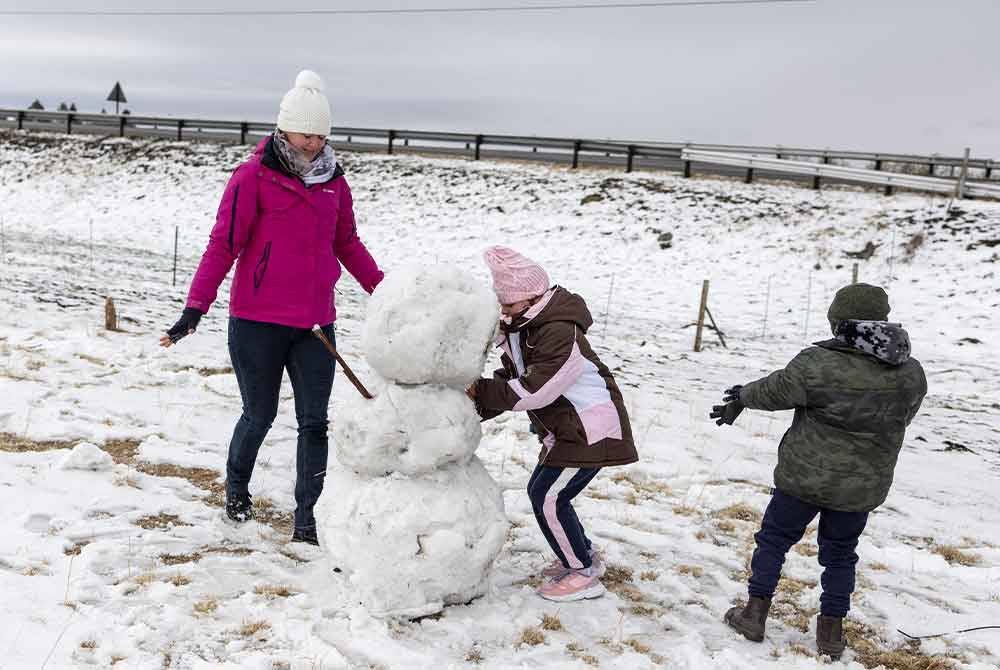 Beberapa penduduk tempatan yang teruja dengan salji tebal membina 'orang salji' di Warden, wilayah Free State. - Foto AFP