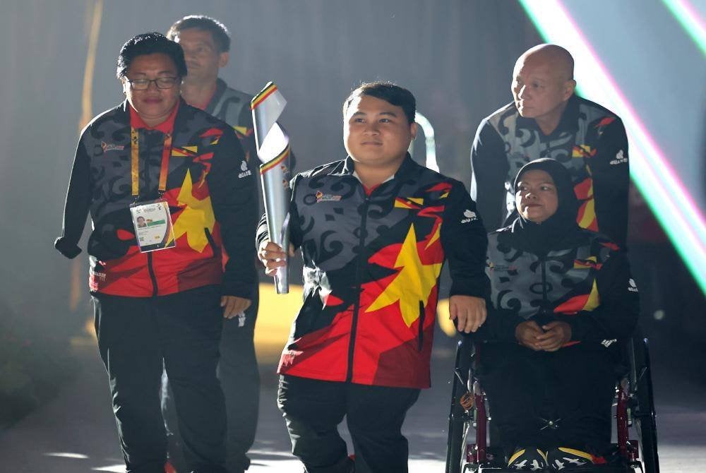 KUCHING, 22 Sept -- Atlet power lifting negara Bonnie Bunyau Gustin membawa obor pada perasmian temasya Para Sukan Malaysia (SUKMA) Sarawak 2024 di Stadium Perpaduan Petra Jaya Kuching, malam ini. Foto Bernama