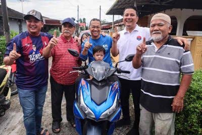 Calon BN di Mahkota, Syed Hussien Syed Abdullah (dua, kanan) bergambar bersama penduduk Taman Ilham selepas meluangkan masa memancing. Foto Bernama.