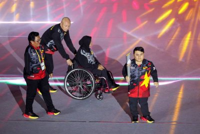 Bonnie Bunyau (kanan) membawa obor untuk dinyalakan pada Majlis Perasmian Temasya Para Sukan Malaysia (Para Sukma) Sarawak 2024 di Stadium Perpaduan Petra Jaya malam ini. Foto Bernama