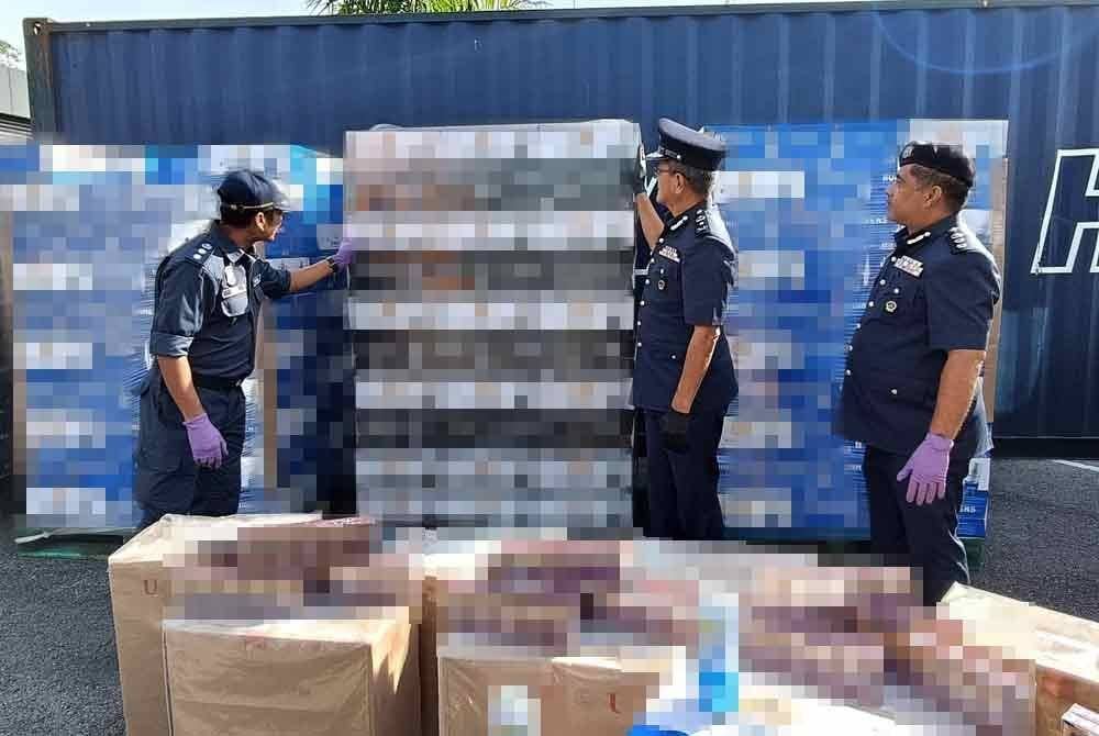 Muhammad Ilyas (kanan) melihat minuman keras dan rokok yang dirampas