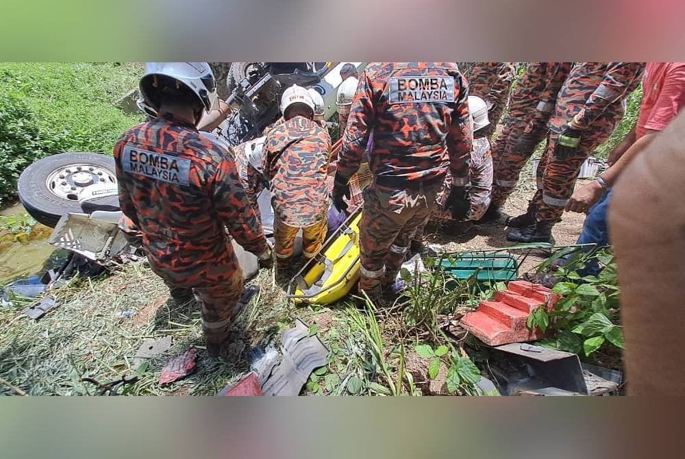 Pasukan bomba melakukan operasi mengeluarkan mangsa yang tertimbus bersama kepala lori dalam kemalangan di Batu 18, Jalan Sandakan-Lahad Datu.