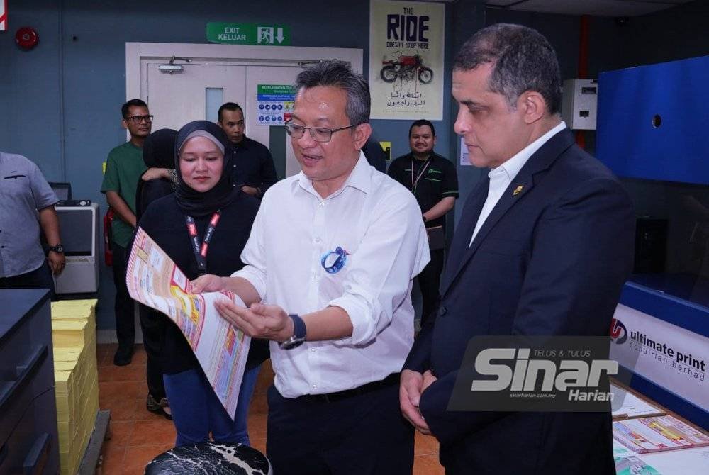 Pengarah Eksekutif Kumpulan Korporat, Kewangan dan Pengurusan Risiko, Akmal Eirfan Mohamed Fauzi (dua dari kanan) memberi penerangan kepada Syed Hamadah ketika lawatan ke kilang operasi akhbar Sinar Harian pada Isnin