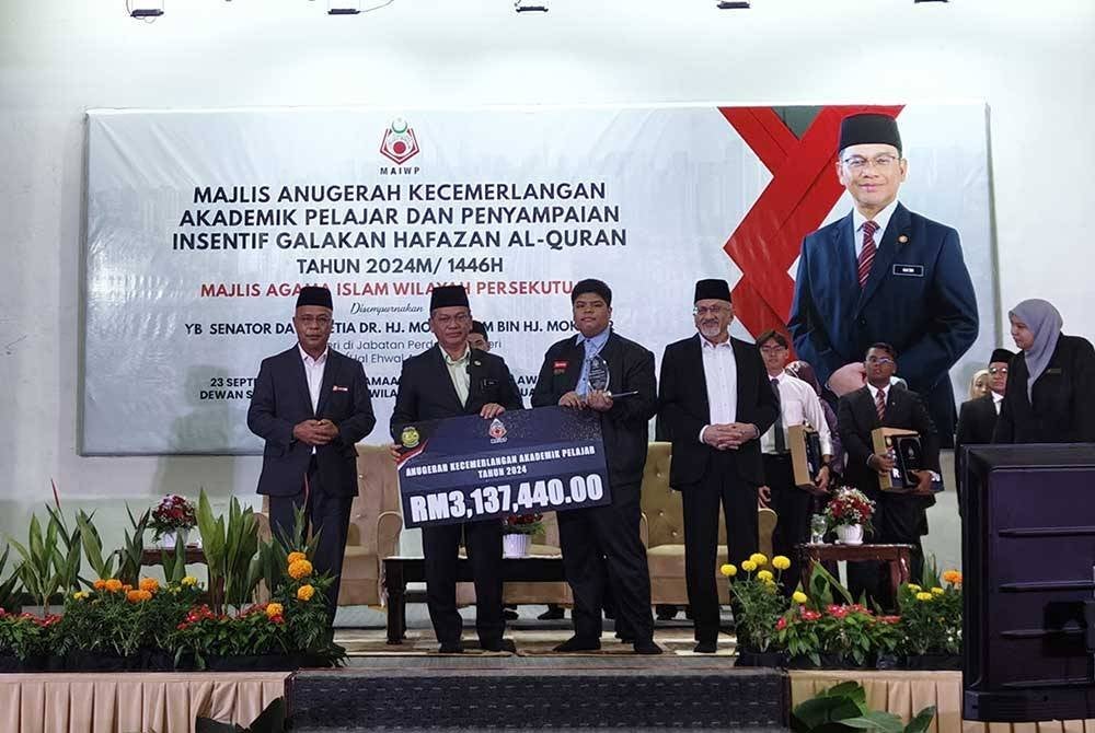 Mohd Na'im menyampaikan gimik penyerahan sumbangan peruntukan RM3.1 juta kepada 698 pelajar cemerlang MAIWP.