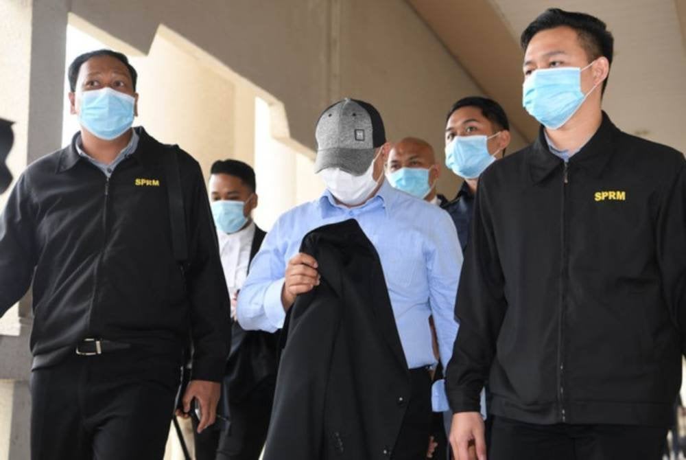 Ahmad Azwan (tengah) didakwa menipu MyIPO dengan memperdayakan pegawai kanan syarikat itu supaya membuat pelaburan ke dalam skim BIMB i-Fund. Foto fail Bernama