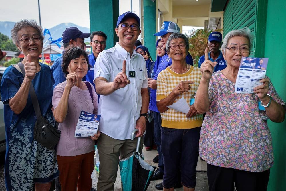 Tengku Zafrul (tengah) menyantuni penduduk setempat ketika mengadakan tinjauan mesra sempena PRK DUN Mahkota di sekitar kawasan Kampung Melayu Dua, pada Isnin. Foto Bernama