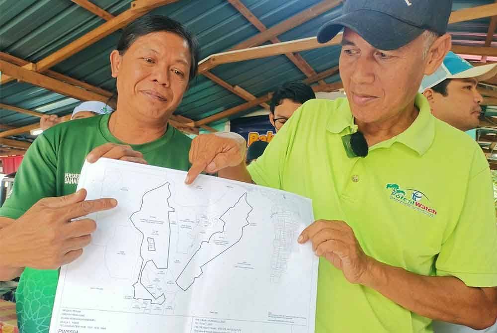 Meor Razak (kanan) bersama Noor Ismady menunjukkan pelan kawasan seluas 548 hektar Hutan Simpan Segari Melintang di Teluk Mengkudu yang dimansuhkan bagi projek pembangunan kuari.