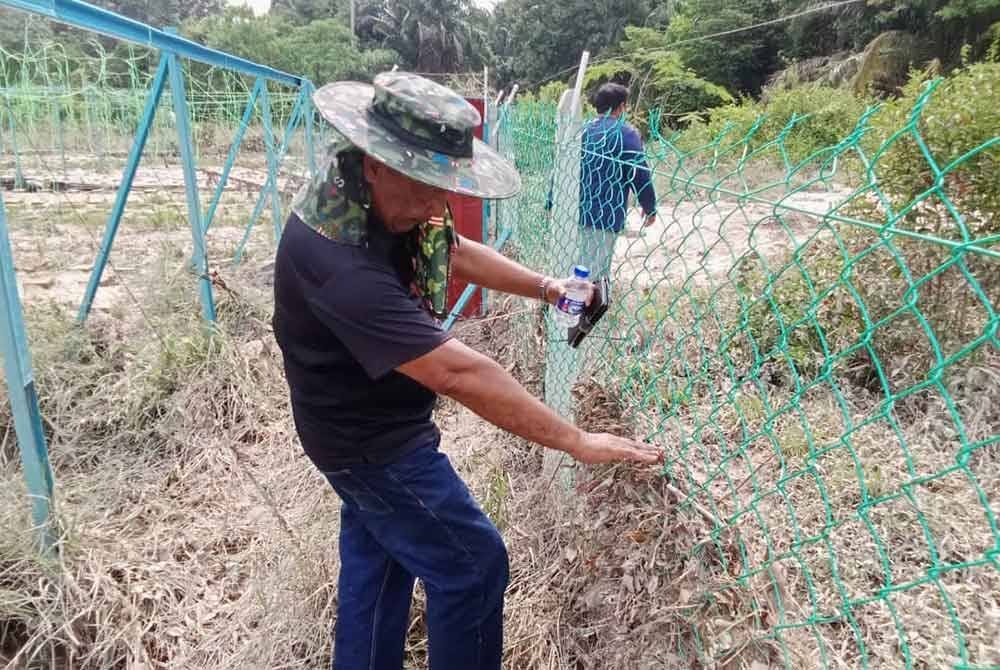 Bapa Muhammad Arif, Hamdan Hashim, 57, menunjukkan paras air banjir dalam kejadian pada Isnin.