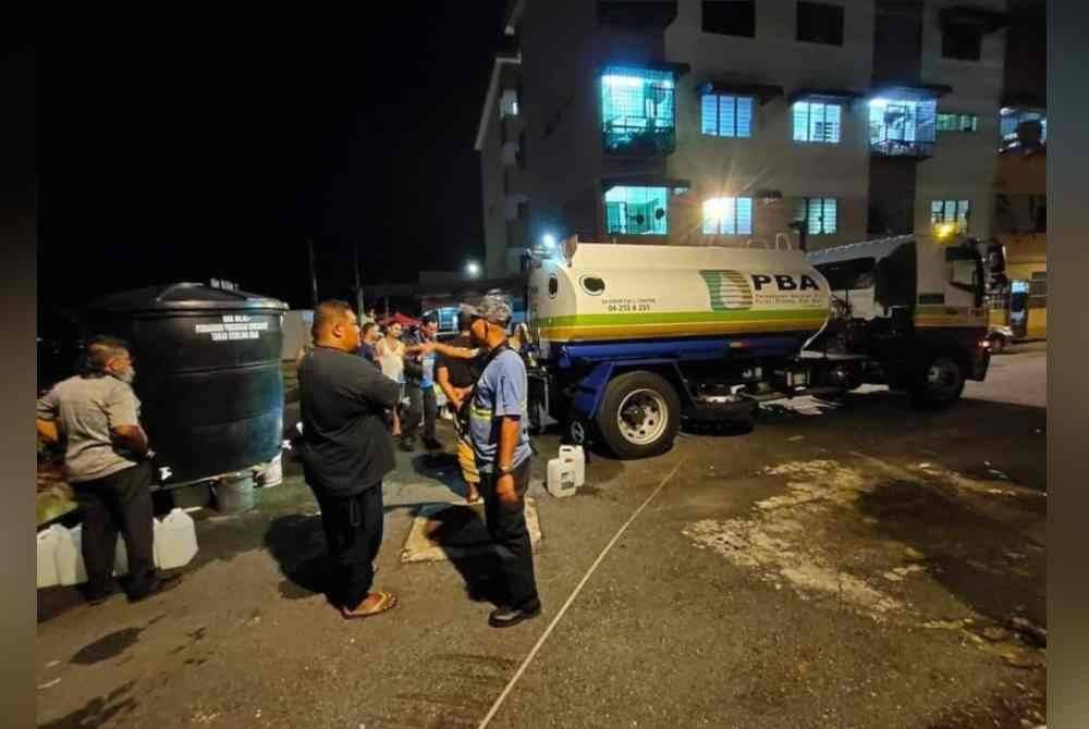 Penduduk mengambil air daripada tangki air yang disediakan PBAPP.