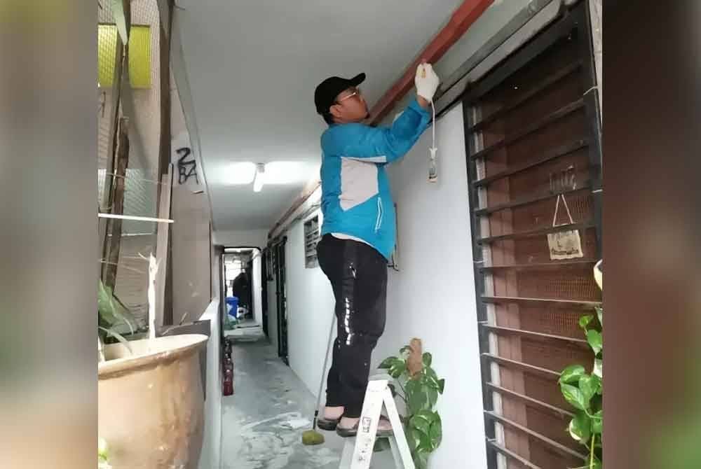 Seorang penduduk yang terlibat dalam usaha ubah suai landskap koridor di tingkat 10.