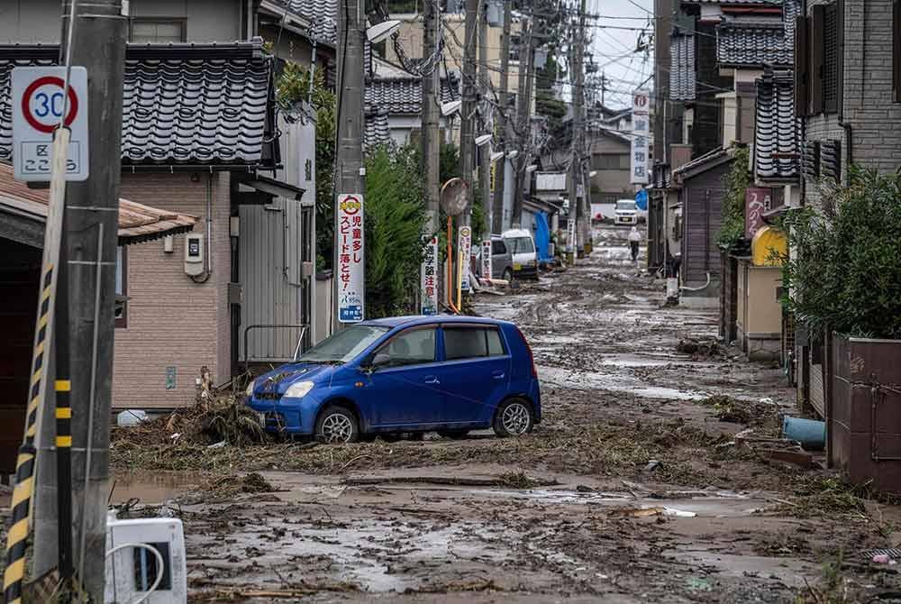 Sebuah kereta terkandas di jalan yang dilitupi lumpur berikutan hujan lebat di bandar Wajima, wilayah Ishikawa pada 22 September 2024. Foto AFP