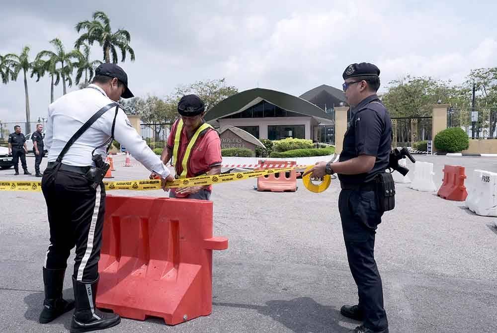 Anggota polis memasang pita polis di sekitar sebuah lubang benam sedalam satu meter di laluan masuk ke Kompleks Bunga Raya Terminal KLIA pada Rabu. Foto Bernama